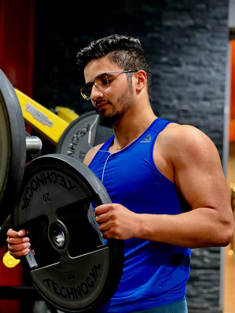 Ilyes loading a 20 kg plate in the gym