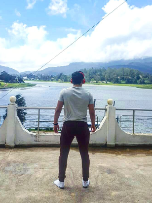 Ilyes looking out over a lake and hills in Sri Lanka